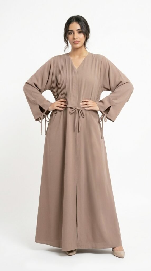 Taupe nida abaya with V-neckline, pin-tuck pleats on one side of the bodice, front bow tie and tie-detail cuffs